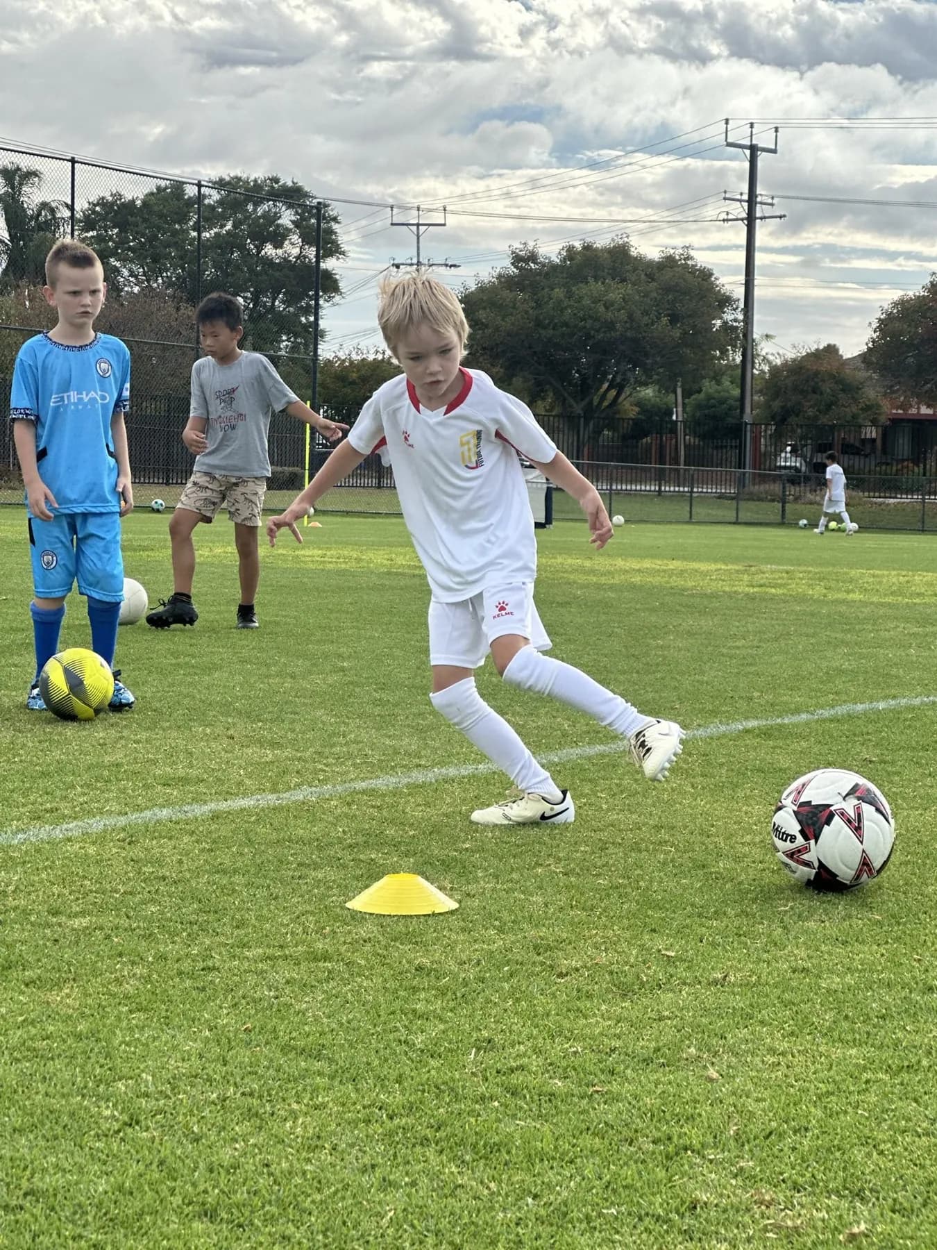 A player dribbling past a cone